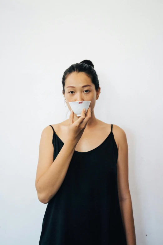 woman in black tank top blowing off a tissue