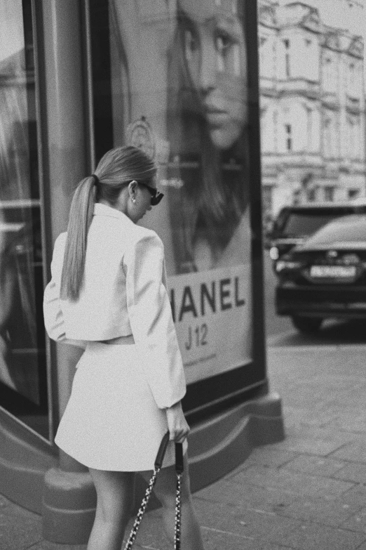 a young woman walks past a chanel store