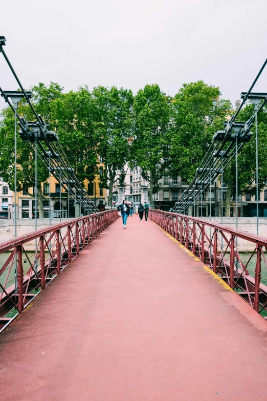 a pink bridge with people walking across it