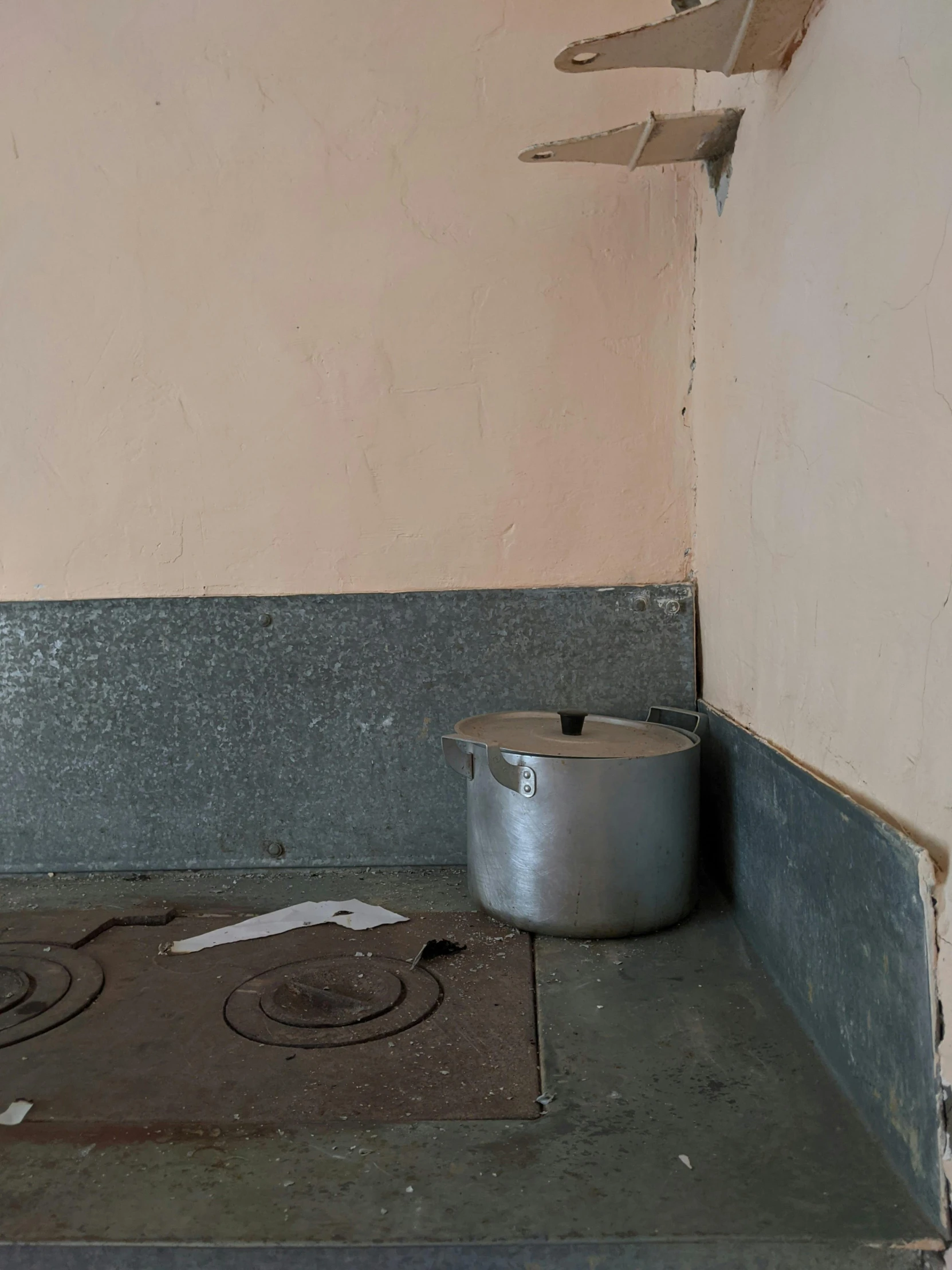 there is a silver pot next to a sink on the floor