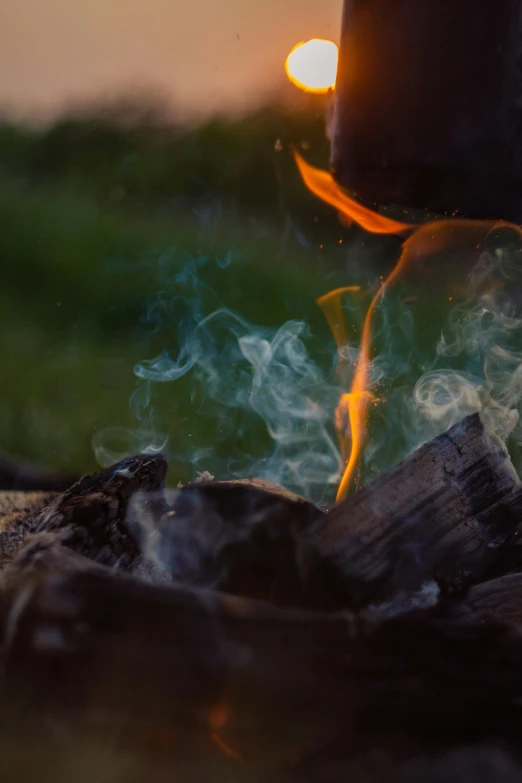 a candle sits on a log with some smoke coming out