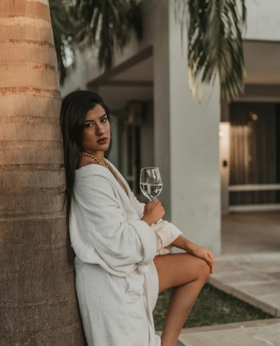 a woman is sitting on the wall holding a glass of wine