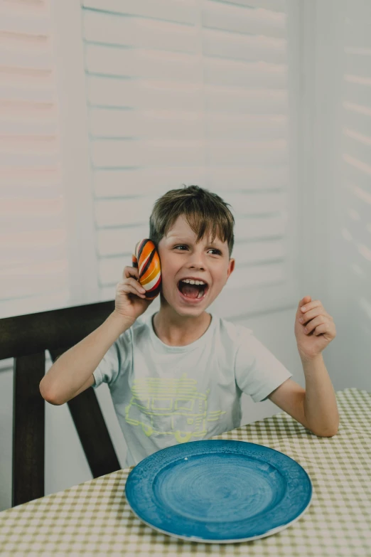 a boy on the phone has his face covered by an object