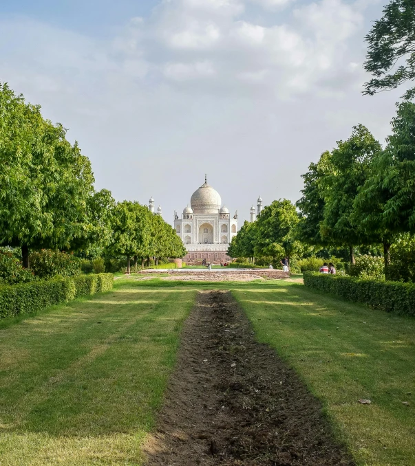 a green area and a building with a statue in the back