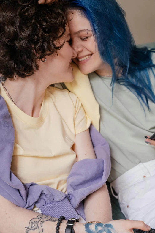 two women are cuddling and laughing while lying together