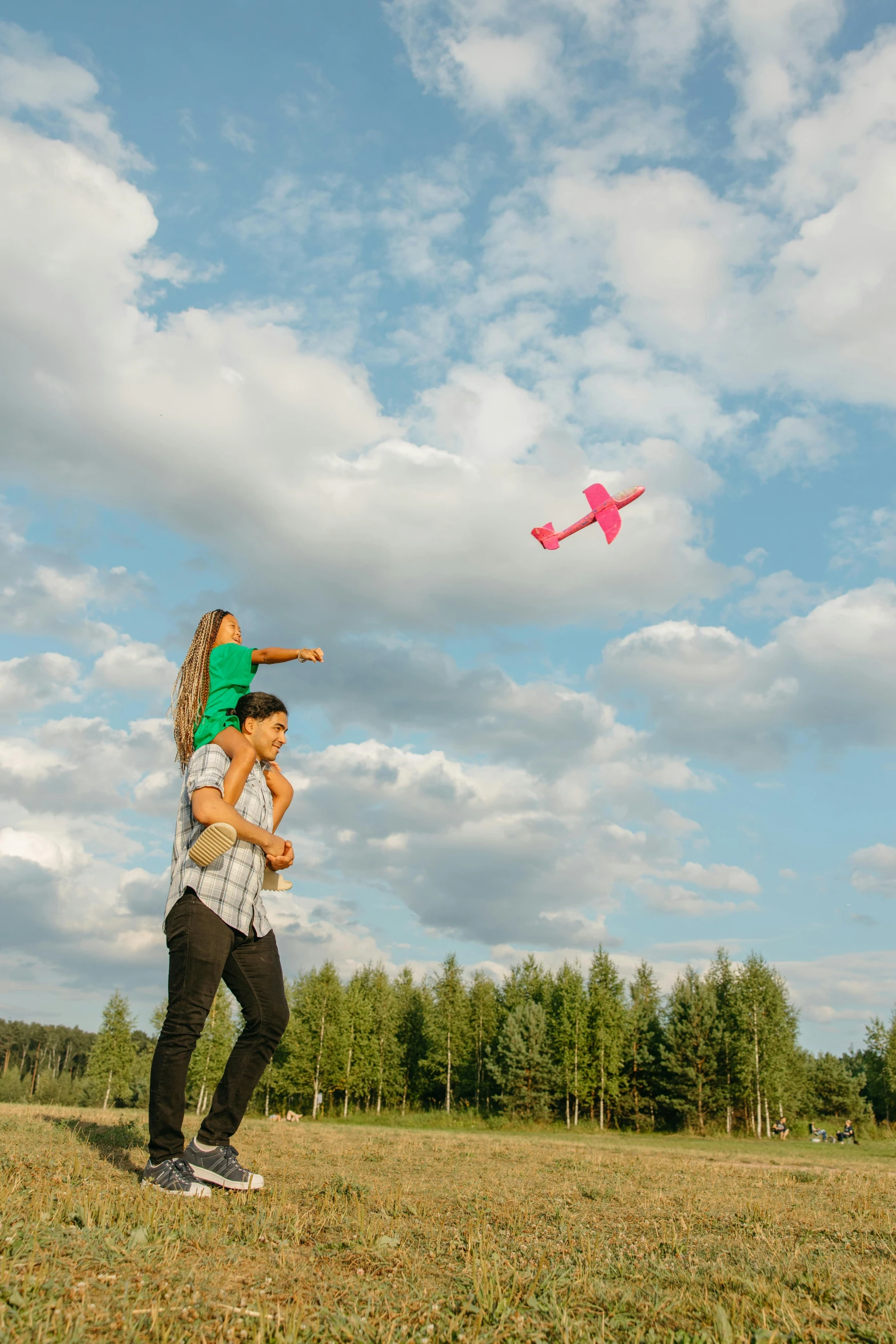 a man in his 30's playing with a girl on a sunny day