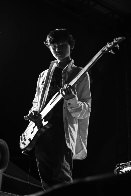 black and white pograph of a young man with an electric guitar