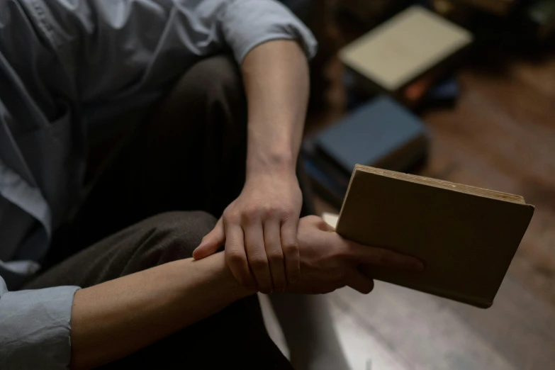 someone holding their hands on top of a wood floor