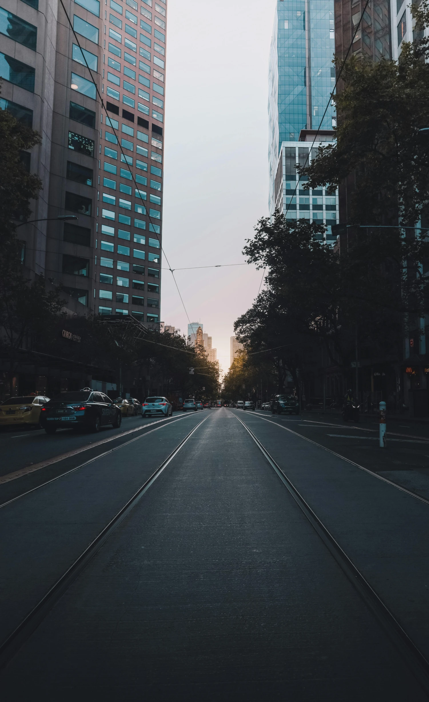 a empty road through the middle of a city with tall buildings