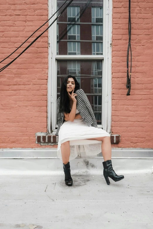 a beautiful woman in black boots and a dress