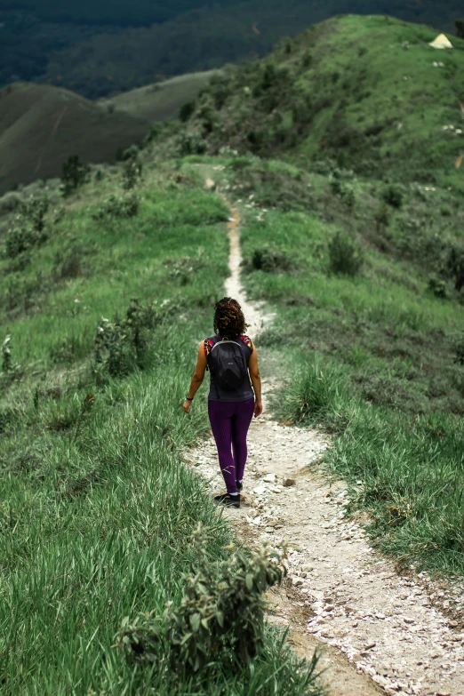 a person walking up the side of a grassy hill