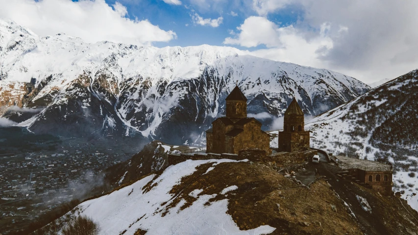 an old building on top of a snow covered mountain