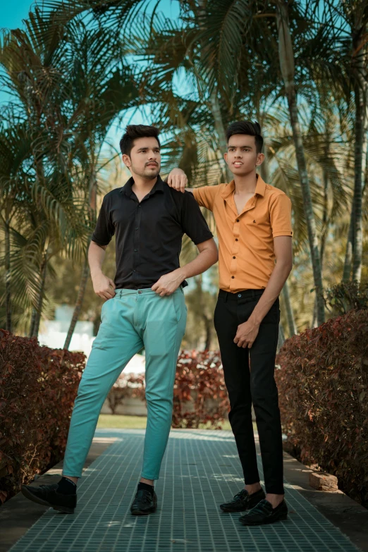 two men in brown shirts are posing