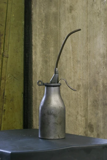 a silver oil can with a small handle