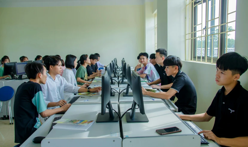 people at tables working on computer screens