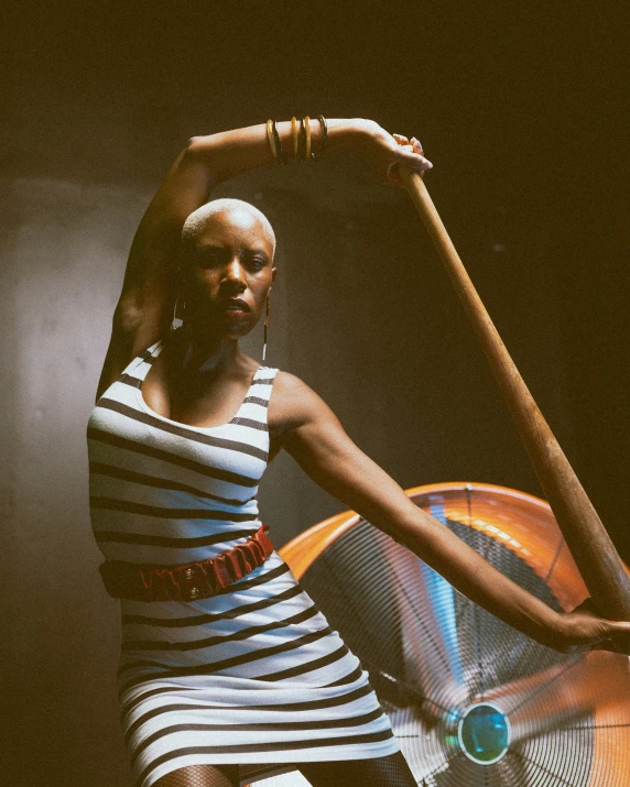 a woman in a striped dress holding a fan