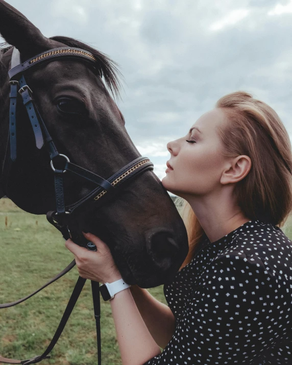 woman hugging a horse while on the grass