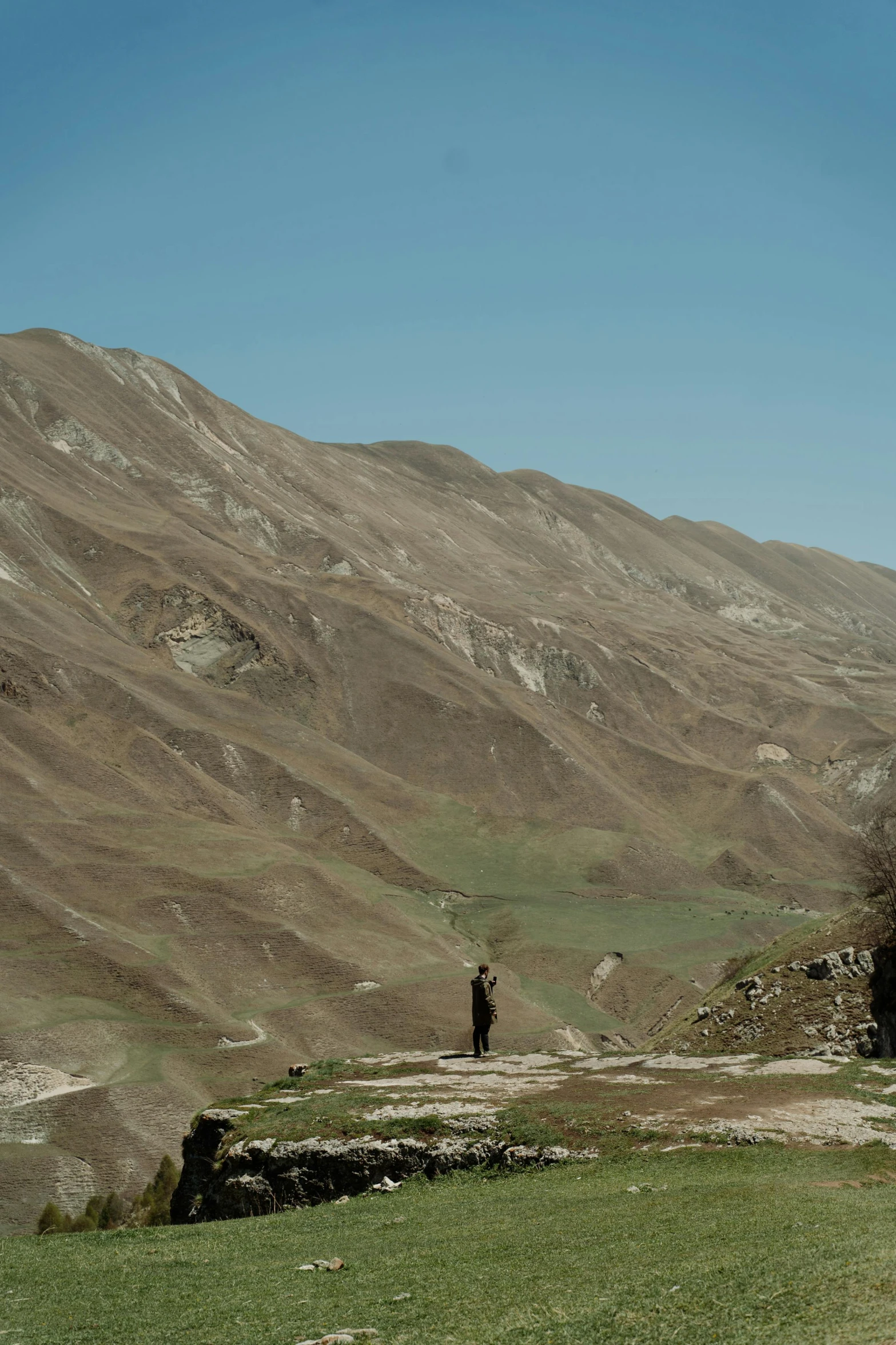 a person with a large hat and a backpack standing on a hill