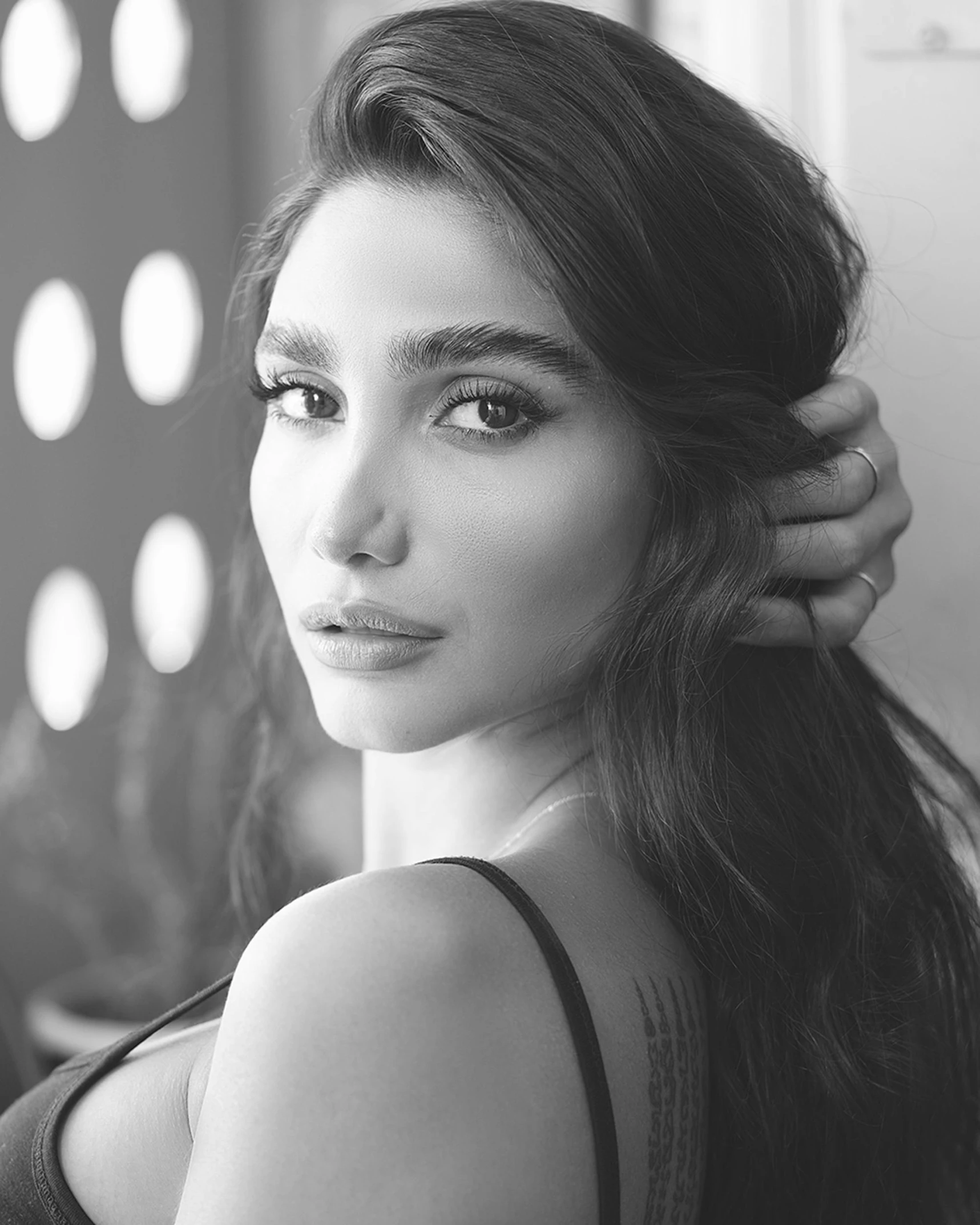 woman with dark brown hair getting her hair styled by pographer