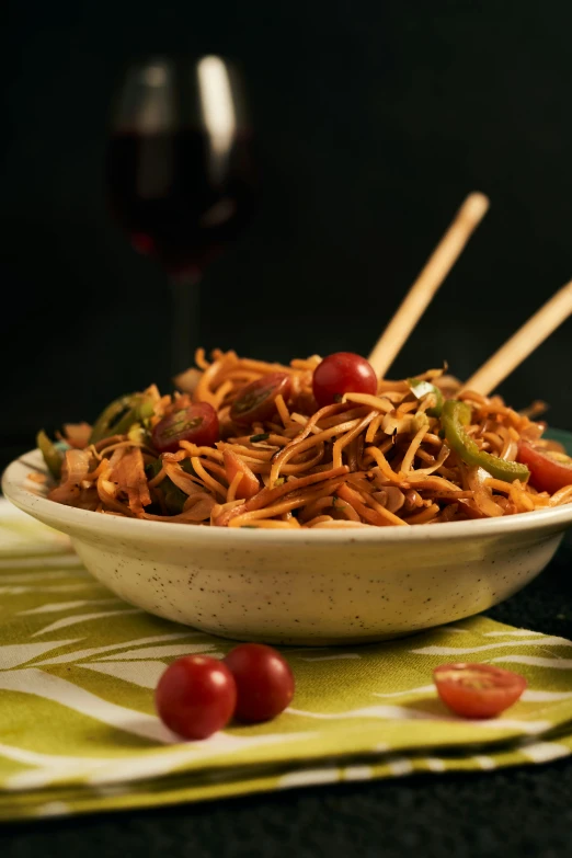 a bowl full of food and chopsticks resting on the table