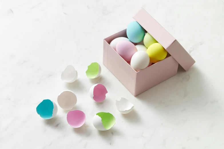 several different colors of bath bombs in a pink box
