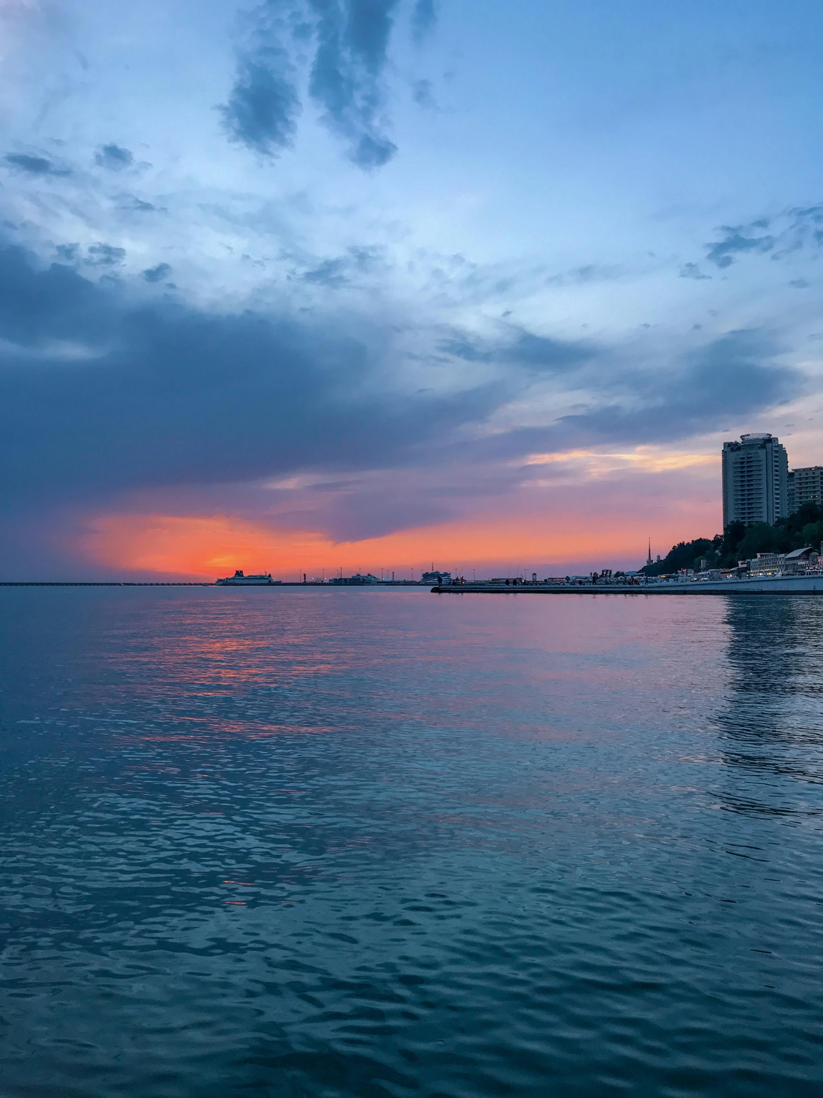 a sunset is reflected in the calm water