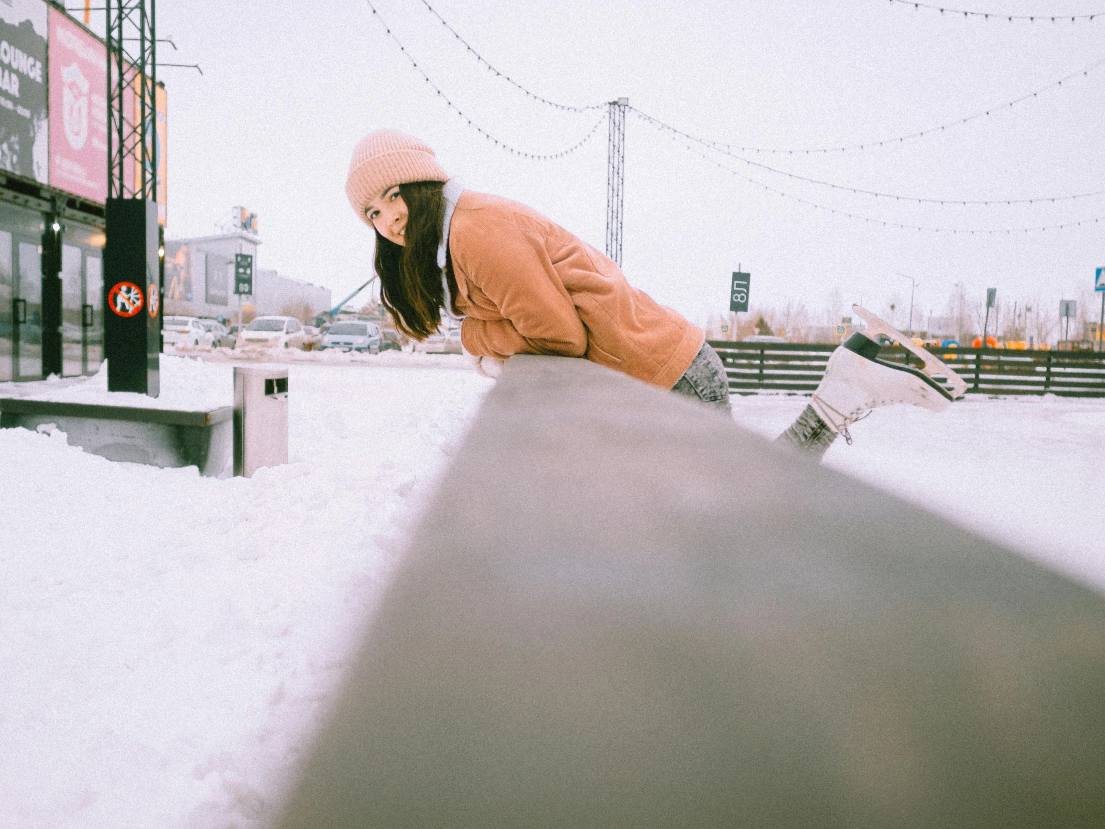 a girl snowboarding on the snow in the city