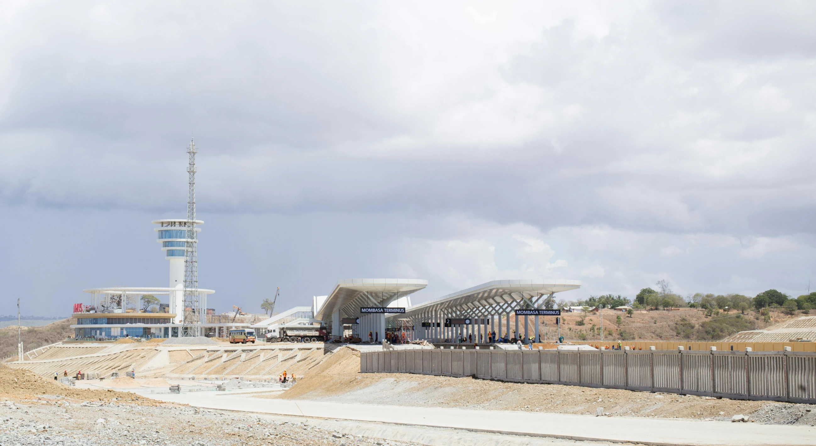 a construction site with people walking around on a cloudy day