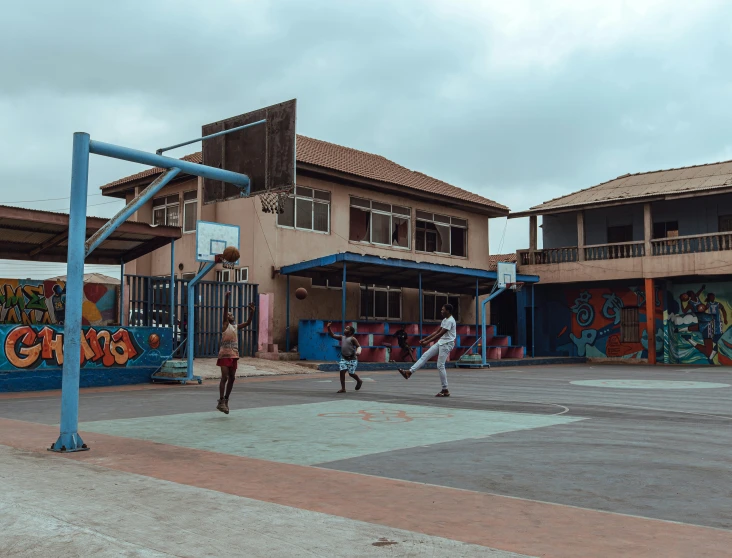 two children are playing baseball in front of a mural