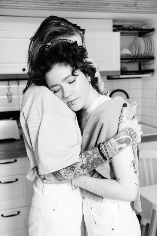 two women in a kitchen emcing each other