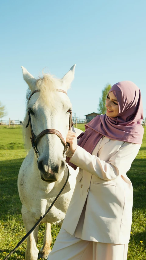 the woman in hijab poses with her horse