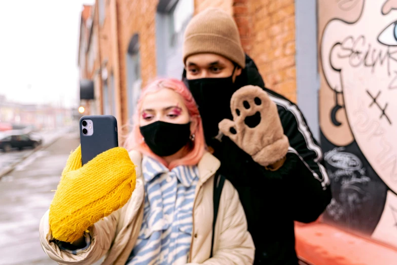 a person taking a selfie with someone wearing a mask