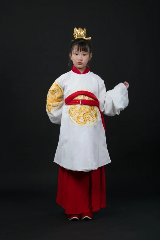 a little asian girl dressed in a costume with golden decorations