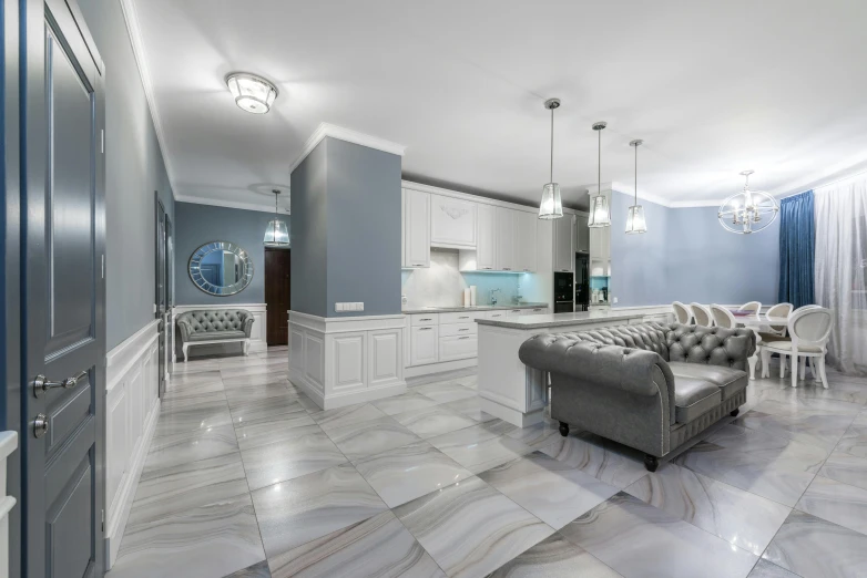 a living room filled with lots of furniture next to a kitchen