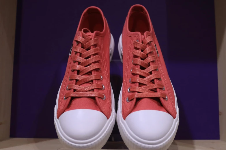 a pair of red and white sneakers with the laces down