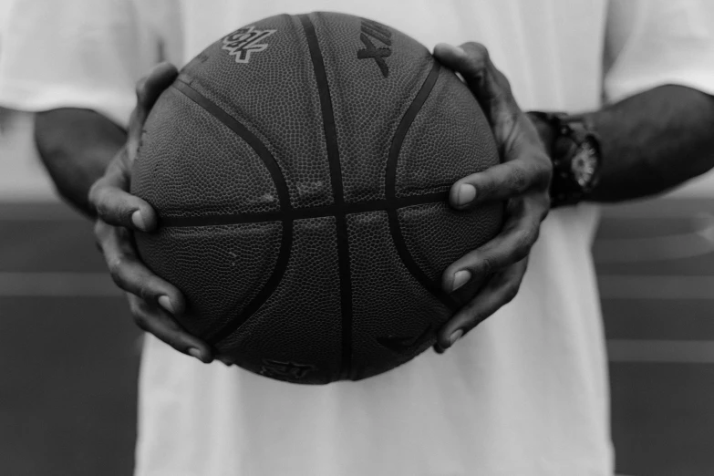 a black and white po shows a man holding a basketball