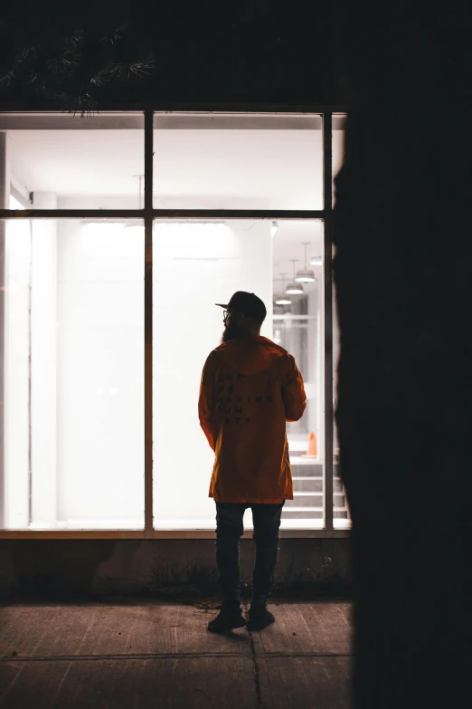 the man is standing by himself outside of a store front window