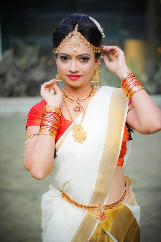 a beautiful indian woman wearing white and gold dress