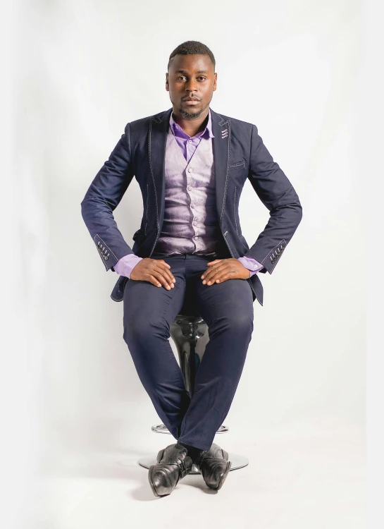 an african american man wearing a purple shirt, tie and blue blazer