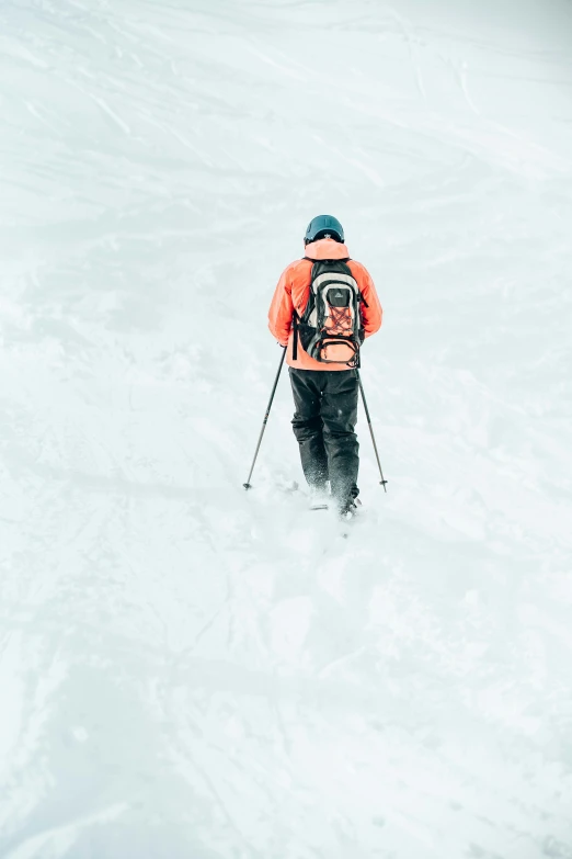 a man in skis standing on the snow looking over his shoulder