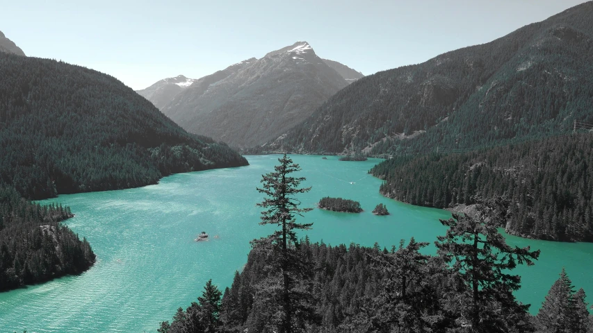 mountains with a green river surrounded by forest