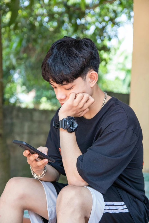 a man sitting down holding his phone to his face