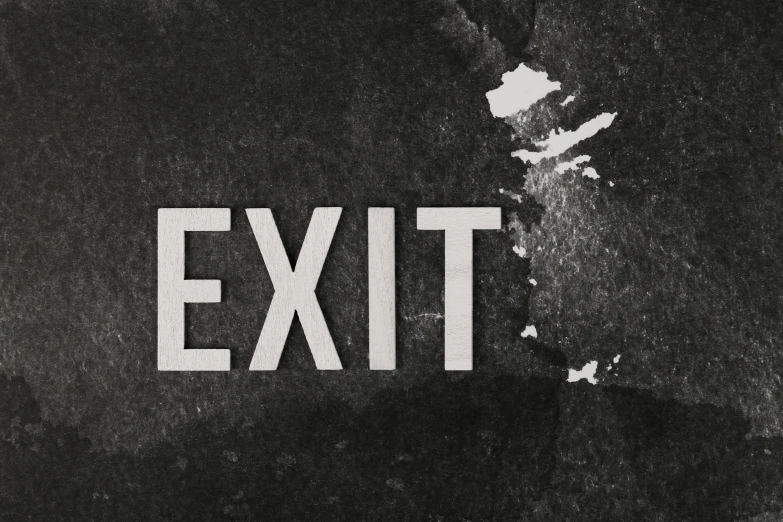 the exit sign is white on black grunge