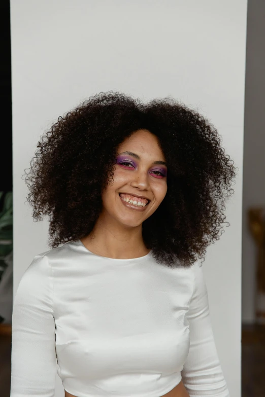 a woman wearing a white dress smiles while sitting