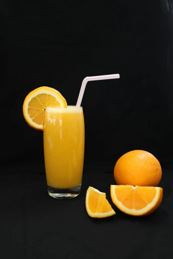 a drink with a straw and some sliced oranges