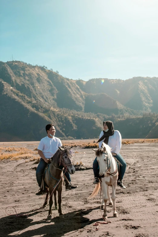 a couple is riding horses in a desert