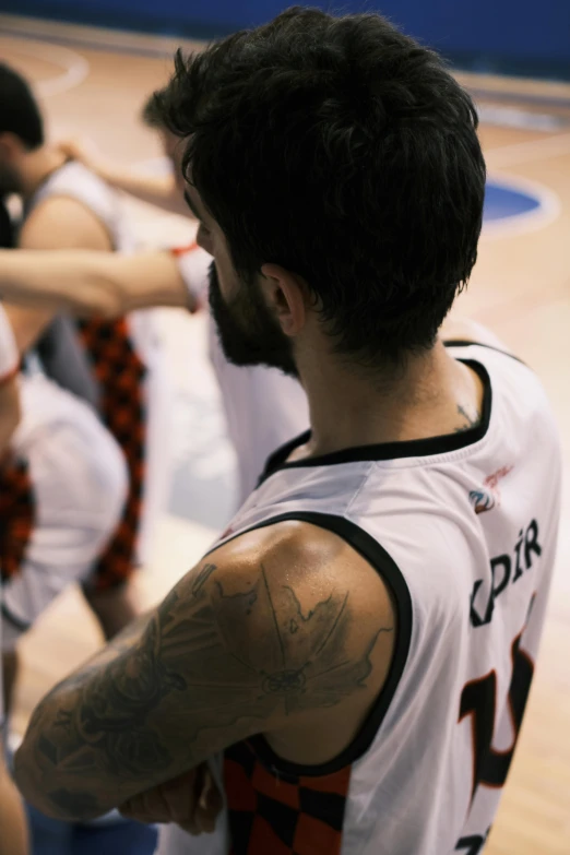 there is a male basketball player that has his arm tattoo