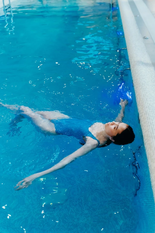 the woman is swimming in the pool with blue water