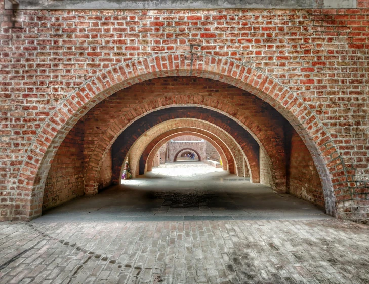 the passage into a tunnel, with many red bricks and arched doorways