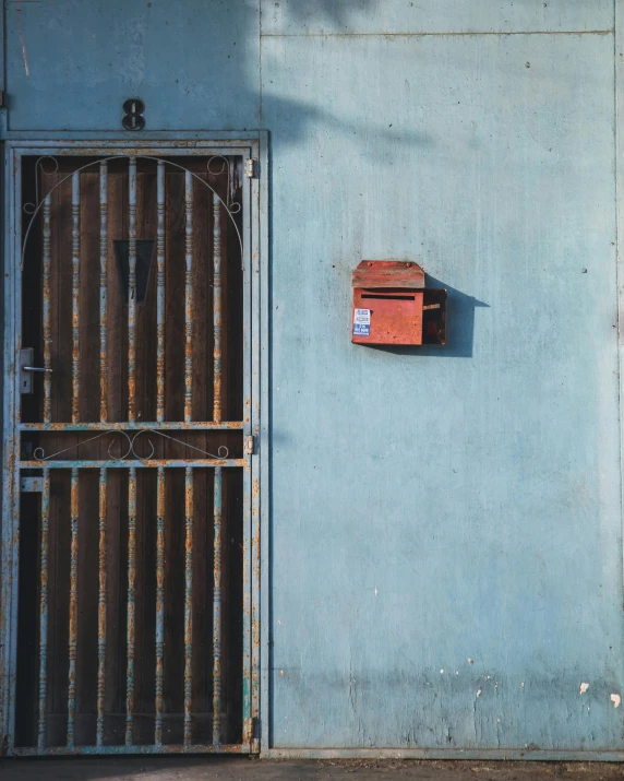 an old rusty gate has a mail box hanging from it